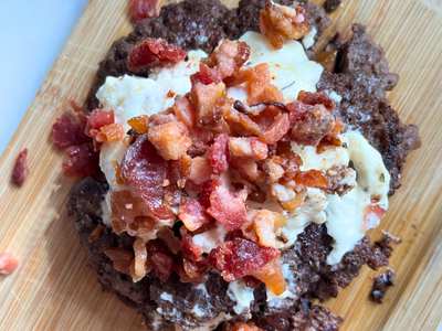 smash burger topped with cream cheese and bacon