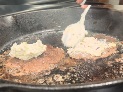 spreading bacon cream cheese on the burgers
